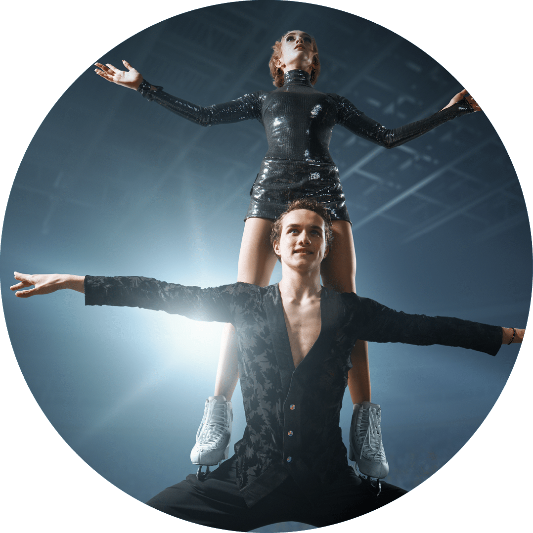 Figure skating  Sports ice skaters couple performs a complicated trick on the professorial ice rink  Ice skaters stand on the ice in the rays of light 