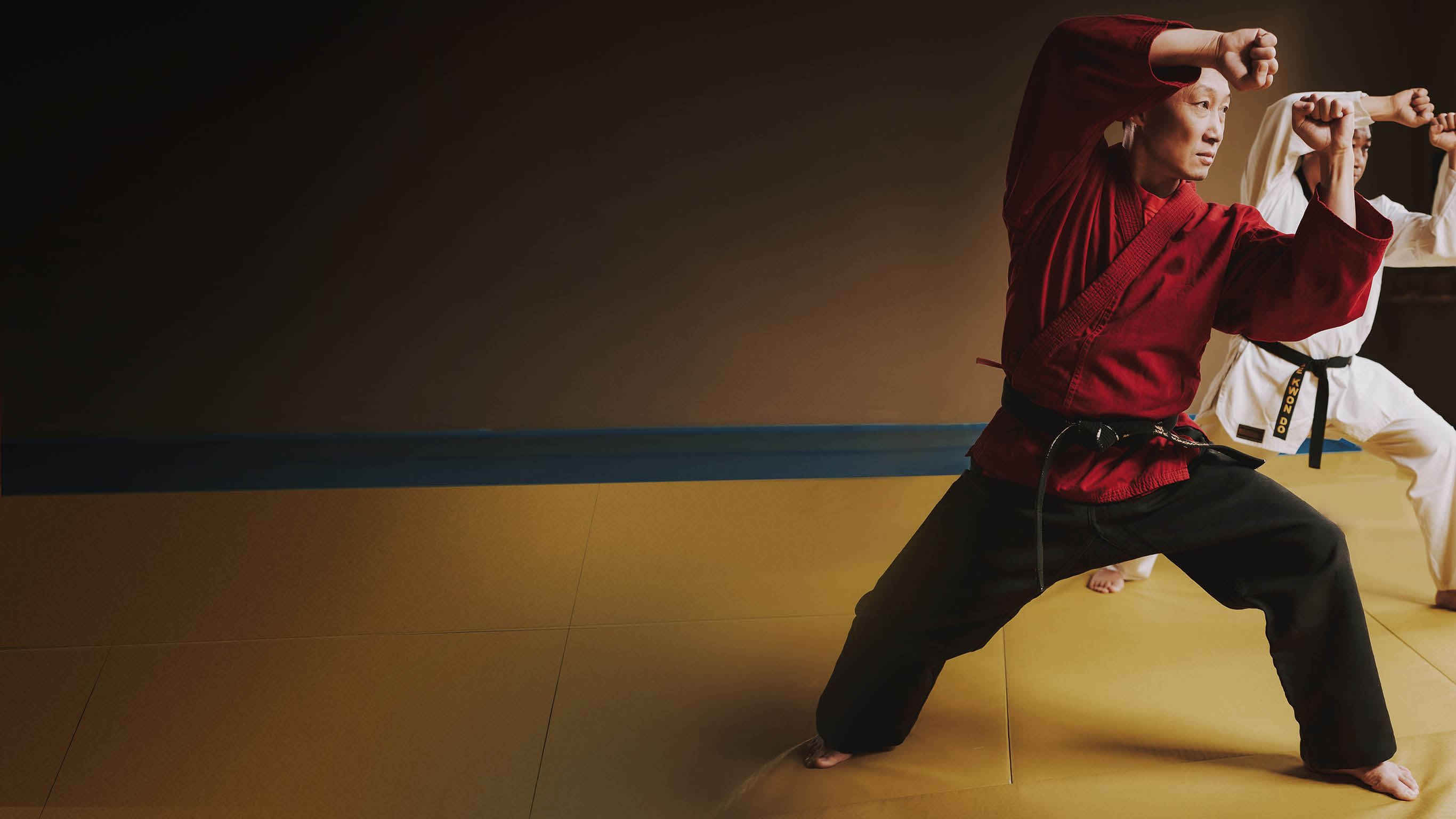 Sensei and two martial arts students with black belts training together 