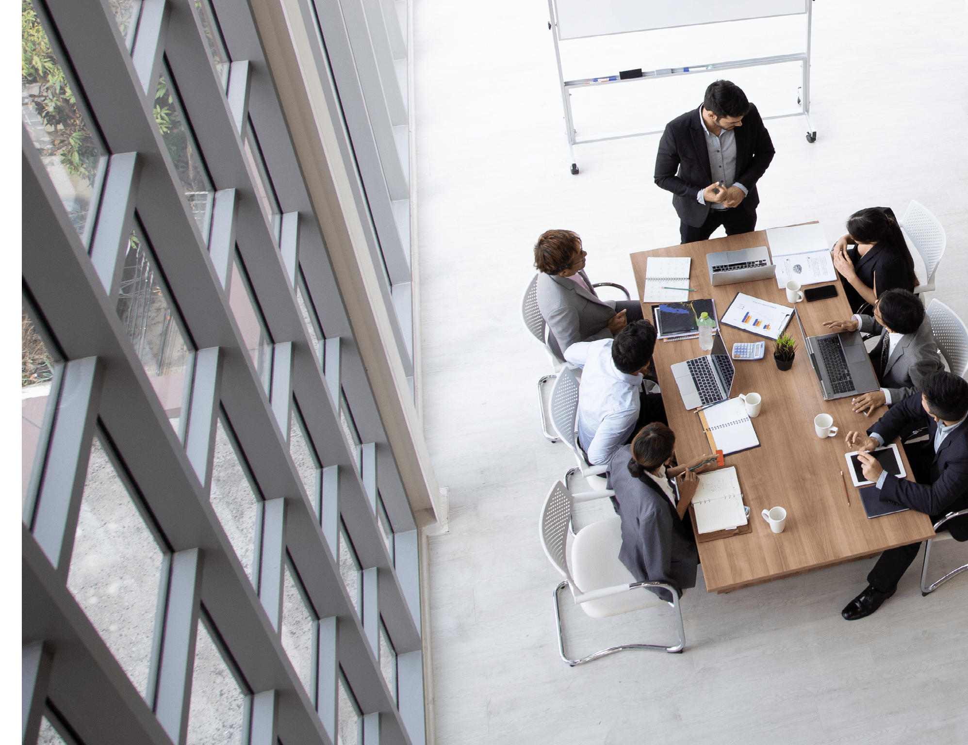 Top view of group of multiethnic busy people working in an office, Aerial view with businessman and businesswoman sitting around a conference table with blank copy space, Business meeting concept